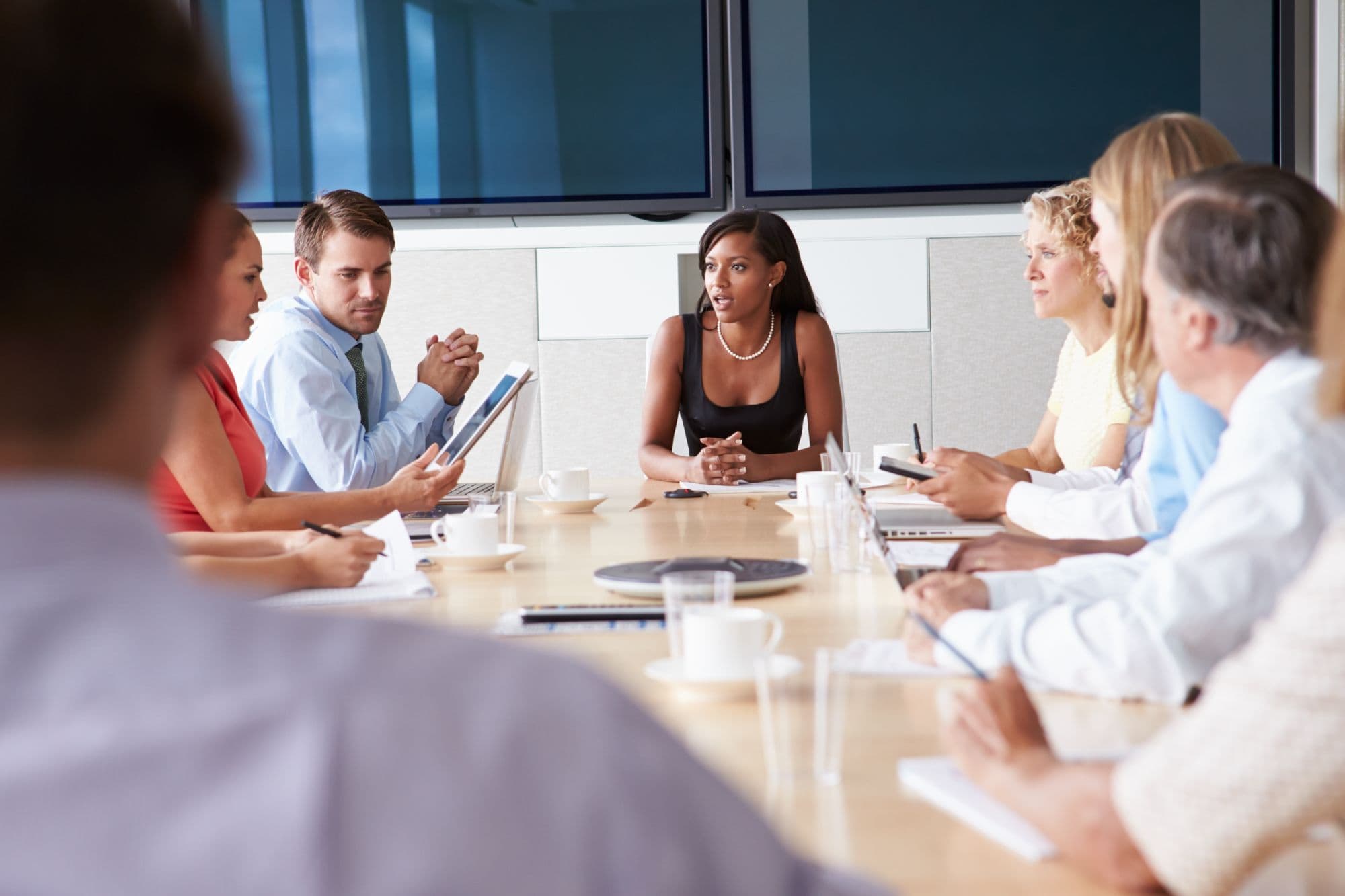 Directors in discussion around a boardroom table